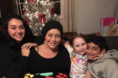 Susie and her children in front of a Christmas tree.