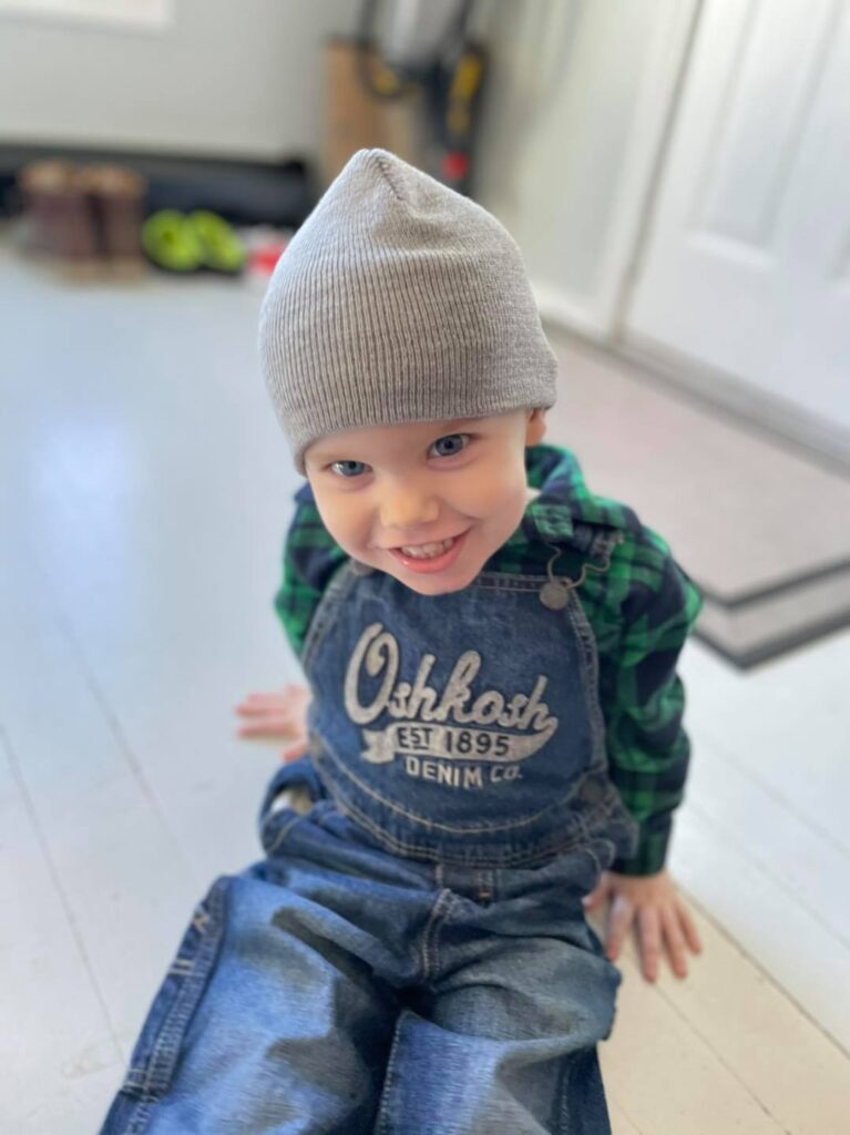 Smiling Rowan in overalls.