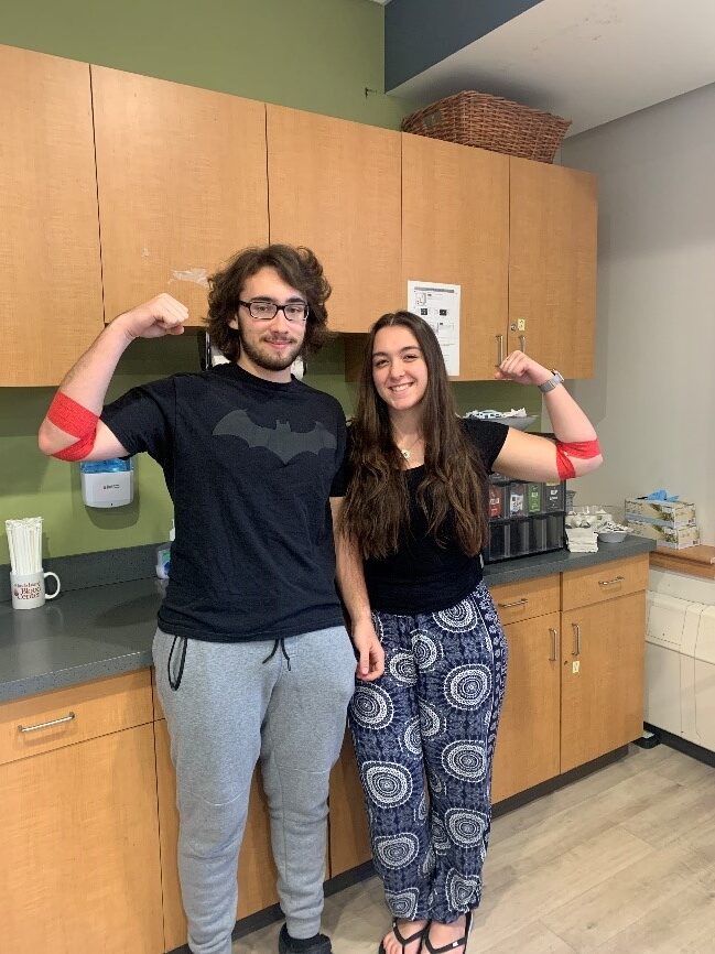 Yound donors Camryn Correira and Michael Robinson posing in snack room after donation.