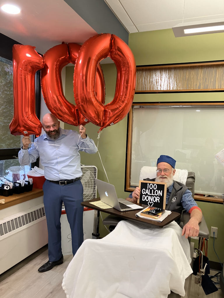Donor David Karoff donating his 100th gallon of blood with RIBC's Beau Tompkins..